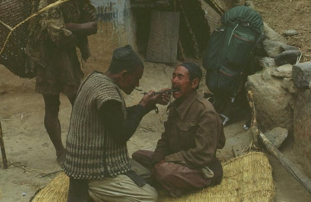 A blacksmith in Gudel, Solukhumbu uses a pair of tongs to extract infected teeth from former British Gurkha Ratna Bali Rai in 1969. Rai had just returned to his village after travelling to Dharan to collect his pension. Photo: STU ULLMANN