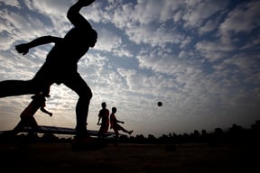 A group of boys play football at the break of day in Tundikhel ground on Monday.