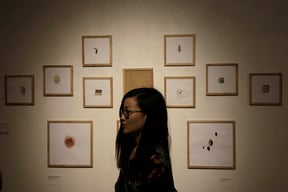 A visitor walks by artworks of German artist Lena Koester during an art exhibition titled 'You are the observer' at Artudio on Friday.