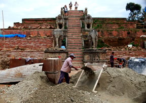 A construction worker sifts sand in front of the Fasidega Temple at Bhaktapur Darbar Square on Thursday.