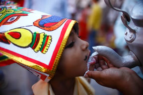 Relatives of the deceased offer milk to a young boy dressed as a cow during the Gai Jatra festival in Basantapur on Friday.