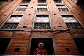 An old woman watches the world go by from the window of her home in Bhaktapur on Friday.