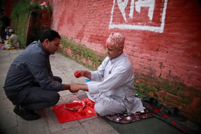 A Hindu priest ties the sacred thread around the wrist of a man on the occasion of Janai Purnima at Pashupati on Thursday.
