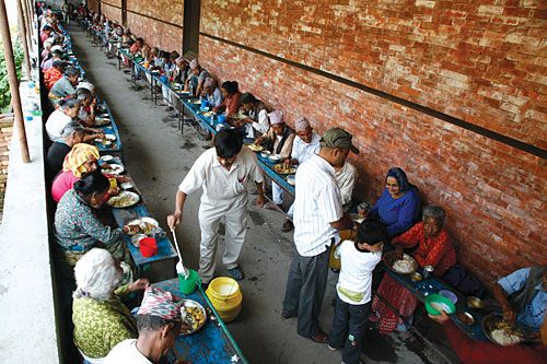 NOT FORGOTTEN: A family from Kathmandu feeds the elderly denizens of Pashupati's Briddha Ashram, Monday.