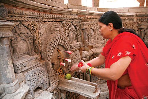 SPECIAL INVITE: A woman makes offerings at Sundari Chok in Patan on Monday, following a ritual to invite Malla king Siddhi Narsingh Malla to change his holy thread in the run-up to Janai Purnima