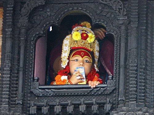 REALLY DIVINE: The Bhairab sips a pack of Real juice while looking down from the window of her official residence at Basantapur on Wednesday during Indra Jatra.