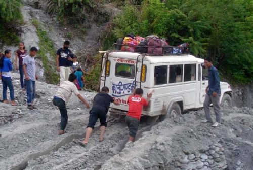 DANGEROUS RIDE: Passengers push a vehicle stuck in Kamarepakho, on hills near Nawalparasi, on Tuesday. Passengers are forced to travel on dangerous roads as the 40 km stretch does not have any water drainage system.