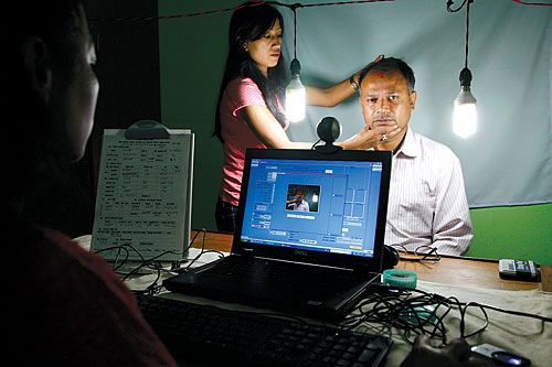 GOING HIGH-TECH: Election Commission officials click a picture of a local in the Ward office at Machendra Bahal, Kathmandu, last Wednesday. This is part of a campaign to upgrade the voters' list and issue national identity cards.