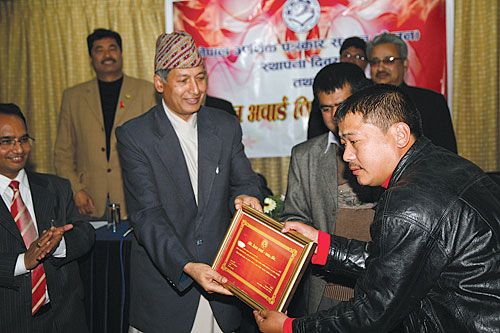 EXCELLENCE AWARDED: Himal Khabarpatrika's Santa Gaha Magar receives the SEJON Outstanding Economic Journalist Award 2010 from Governor Yubraj Khatiwada, Wednesday. Magar received the award for his investigative reporting on financial fraud by Unity Life International.