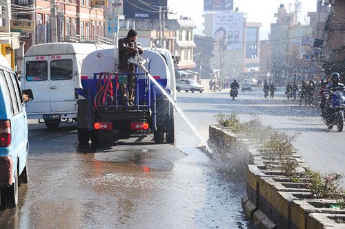 SHOWER TIME: The Kathmandu Metropolitan Office cleans up the dust-caked road dividers in Rabi Bhawan early Thursday morning.
