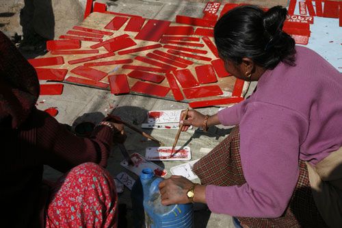 CASHING IN: Two housewives help a local painter meet the demand for painted number plates. Paint shops have been getting hundreds of orders daily after Valley Traffic Police started penalising digital number plates.