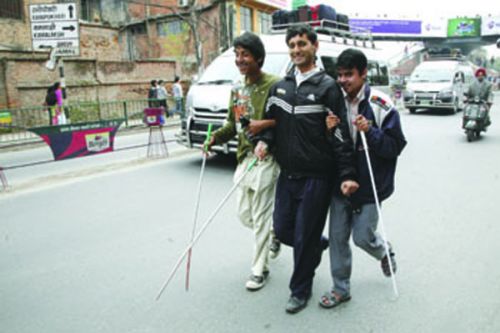 WITH A LITTLE HELP FROM MY FRIENDS: three visually impaired men hand-in-hand in Jamal on Friday. With footpaths encraoched on by street vendors, there is little space for pedestrians.