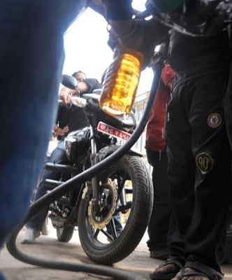 FILL ME UP: A motorcyclist looks on as the attendent at a petrol pump in Kumaripati, Lalitpur, fills petrol in a bottle.
