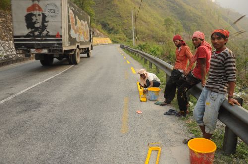 THIS WAY: Workers mark lines with yellow paint on the Prithivi Highway on Saturday.