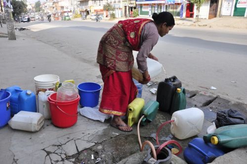 ONE BY ONE: A local fills her water jars from the main line in Kuleshwor, Kathmandu.