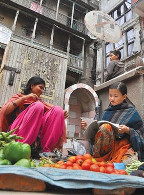 MORNING TUTIONS: A seventh grader finishes her homework while her sister-in-law attends their vegetable stall at Naradevi, Kathmandu, on Sunday.