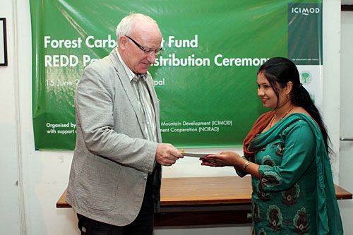 CARBON CREDITS: ICIMOD Director General Andreas Schild hands over a cheque of US $27,560 to Gorkha's Community Forest User Groups on Wednesday under the Forest Carbon Trust Fund. The fund offers rewards for sequestering of carbon emissions.