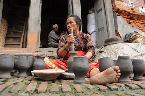FINISHING TOUCHES: An old craftwoman checks her clay pots before setting them to dry at a shop in Talako Pottery Square in Bhaktapur on Friday.