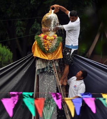 MILK SHOWER: A priest offers milk to the snake idol at Nag Pokhari, Kathmandu, on Thursday morning on the occasion of Nag Panchami when serpent gods are worshipped.