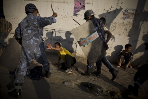 Armed police force members charge at the violent demonstrators.