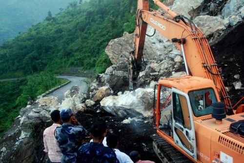 HALFWAY THERE: Police directing operations to open the Dharan-Dhankuta Highway by drilling through rocks brought down by a massive slide. The road has been blocked since Sunday, cutting off a large part of eastern Nepal. Debris from 40m road have been removed, but there is another 40m to go.