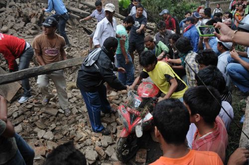 QUAKE EFFECT: Locals recover a motorbike burried under a rubble in Bhaktapur after the Sunday's earthquake.