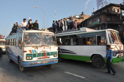 STOP! Traffic police stop overcrowded public buses heading towards Kathmandu at Suryabinayak, Bhaktapur, and ask passengers traveling on the bus's roof to get down, Monday.
