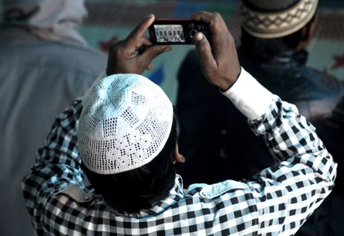 EID IN PICTURES: A man takes a photo with his mobile as his friends offer prayers on the occasion of Bakr Eid at Kashmiri Mosque, Ratna Park, on Monday.