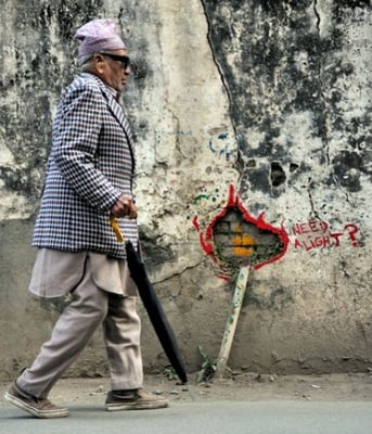 OF COURSE! A man walks past a graffiti in Basantapur that reads "Need a light?" on Tuesday evening. The Nepal Electricity Authority increased power-cut from 40 hours to 69 hours a week Tuesday onwards.