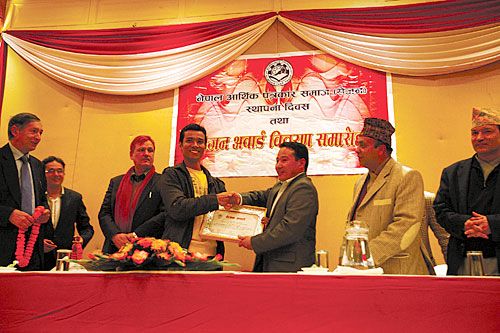 ECONOMY MATTERS: Dambar Krishna Shrestha, correspondent of Himal Khabarpatrika receives the Outstanding Economic Journalist Award 2011 from Finance Minister Barsha Man Pun in Kathmandu on Monday. The award was conferred by Society of Economic Journalists of Nepal (SEJON) for his coverage on casinos in the Valley.