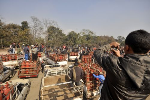 EMPTY JARS: A local, who was part of a protest rally agains shortage of liquefied petroleum gas (LPG) and petroleum products, takes a photo of trucks carrying empty gas cylinders at Khula Manch on Wednesday.