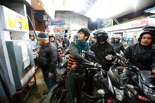 FILL ME UP: After several hours of wait, a petrol pump in Kalimati finally begins to suppy petrol to motorcyclists and cars on Wednesday evening.