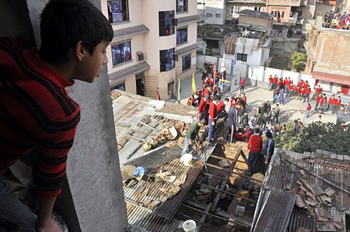 FIRE FIRE: A young boy looks on as locals and students try to put out fire at a house in Dallu before the arrival of a fire brigade.