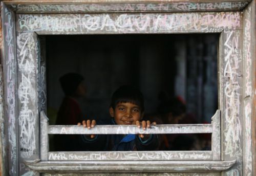 WINDOW OF WORDS: A boy looks out of a window near the Saraswati temple in Swyambhunath premises on Saturday.