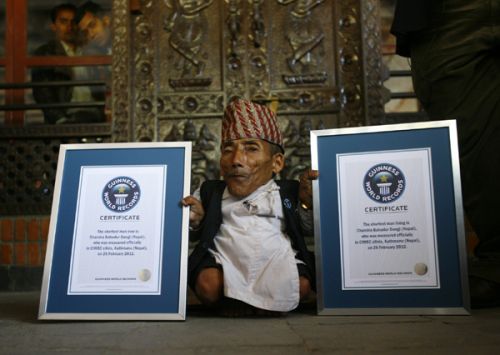 STANDING TALL: Seventy-two year old Chandra Bahadur Dangi shows off his Guinness World Record certificate which declares him the shortest person in the world. At 22 inches, Dangi is the shortest man to be ever measured by Guinness World Record.