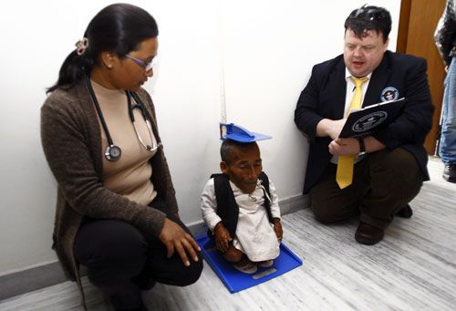 STANDING TALL: Editor-in-Chief of Guinness World Record, Craig Glenday (right) measures Chandra Bahadur Dangi, 72, in Kathmandu on Monday. Dangi was announced the world's shortest man alive, as well as the shortest person ever measured by the Guinness World Records.