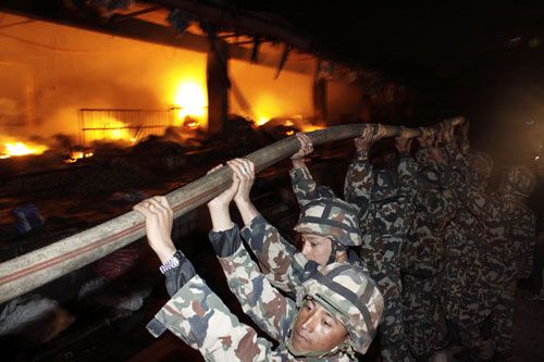 ALL FOR ONE: Fire fighters from Nepal Army try to control fire in the premises of Kalimati Fruits and Vegetable Market, Kathmandu. The fire left six dead and damaged property worth over Rs 80 million.