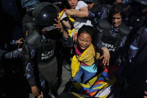 CHAINED DOWN: A Tibetan protestor being dragged in chains outside Chinese Embassy's Visa section office in Hattisar by security personnel on Saturday. Six protestors waving Tibetan flag with 'No Human Rights in Tibet' slogans were also detained, the police refused to offer information on those in custody.