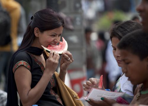 JUICY DELIGHT: Pedestrians enjoy watermelons at a street fruit vendor in Ratnapark, Kathmandu, on Sunday. With temperature rising, fruit vendor have experienced an increase in their sales.