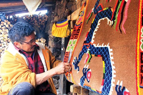 FINISHING TOUCH: A Tibetan carpet weaver in Olangchung Gola, a village in Taplejung, adds finishing touches to complete his creation, last Thursday.