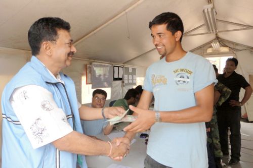 CHECKING OUT: Special Committee member Sandan Prasad Kurmi hands over a cheque and travel allowance to Man Bahadur Bista, a commander at Jhyaltungdanda-based fourth division Maoist camp in Nawalparasi, who has opted for voluntary retirement. Out of 652 ex-combatants in the camp, 350 have chosen voluntary retirement.