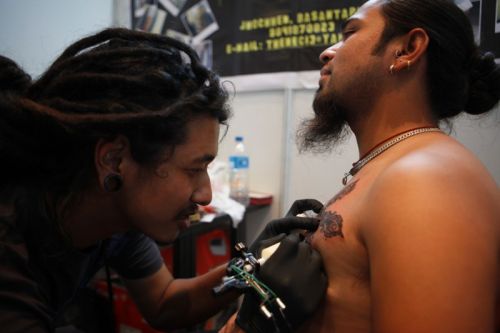LASTING IMPRESSIONS: A tattoo artist inks a client at the Second International Nepal Tattoo Convention on Saturday in Kathmandu.