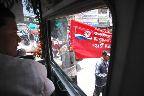 WORK JAMMED: A public bus driver looks on as a rally marking May Day takes on the streets, obstructing the traffic in Kathmandu on Tuesday.