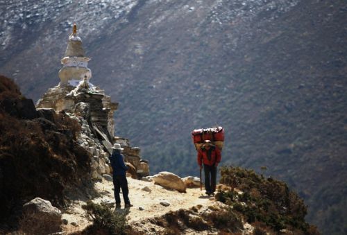 CROSSING PATHS: A local porter walks past a tourist on Tuesday on a trekking route that leads to Pangboche in Khumbu region.