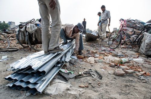 SALVAGE VALUE: A kabadi-wala flattening scrap sheets of zinc roofing from the demolished squatter residences at Thapathali on Tuesday afternoon.