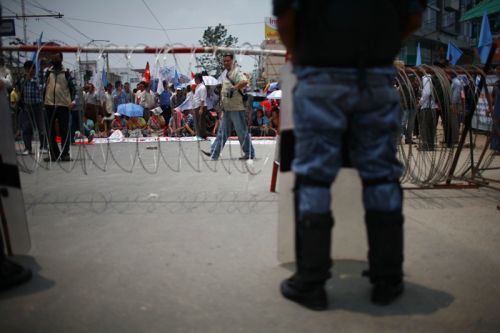 BEHIND THE WIRES: A security personnel stands gaurd outside the CA building in Baneshwor, as various groups sit with different demands on Sunday, the day the constitution deadline expires.