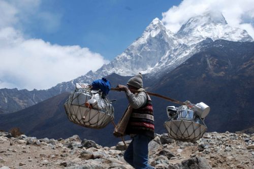 BIZ AS USUAL: A trader walks uphill in Khumjum, Solukhumbu on Tuesday, with Mount Amadalam shining behind.