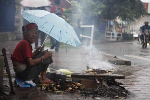 MONSOON SNACKS: An old lady sells roasted corn near Bhadrakali Temple, Kathmandu, on Wednesday afternoon as the rain pours down.  PIC