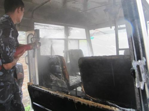 DAMAGE CONTROL: Police putting out flames in a school bus, fire-bombed by Maoist supporters on Monday morning. Promt action prevented the fire from spreading. PIC