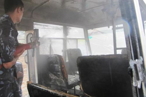 DAMAGE CONTROL: Police putting out flames in a school bus, fire-bombed by Maoist supporters on Monday morning. Prompt action prevented the fire from spreading. PIC